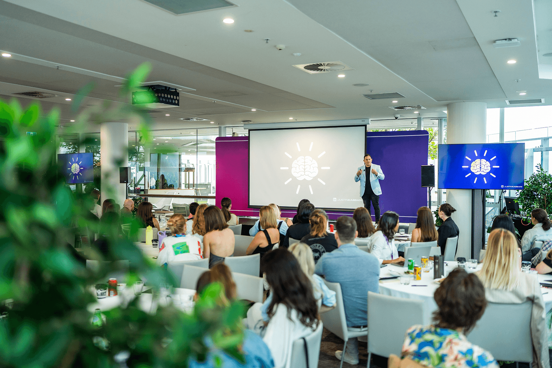 Justin Kabbani speaking on stage at a major conference